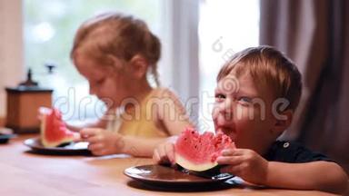 两个可爱的孩子女孩和男孩在吃西瓜。 兄妹俩坐在餐桌前，一起吃了一顿饭..